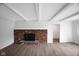 Living room showcases wood floors, white-painted ceiling beams, and brick fireplace at 3148 Arbutus Dr, Indianapolis, IN 46224