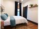 Cozy bedroom with hardwood floors, decorative rug, and black trim around the door and window at 321 N Rangeline Rd, Carmel, IN 46032