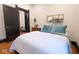 Bright bedroom with hardwood floors, white bedding, and black trim on door and baseboards at 321 N Rangeline Rd, Carmel, IN 46032