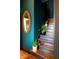 Detailed staircase features a deep blue wall and gold mirror, adding to the home's elegance at 321 N Rangeline Rd, Carmel, IN 46032