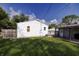 A spacious backyard featuring a well-maintained lawn, white siding, and a covered patio at 321 S Biltmore Ave, Indianapolis, IN 46241