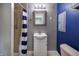 Bathroom featuring a toilet, sink with vanity, blue accent wall, and a shower with blue and white curtain at 321 S Biltmore Ave, Indianapolis, IN 46241