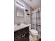 Bathroom featuring a stylish vanity with dark cabinets, updated fixtures, and a shower with tile surround at 321 S Biltmore Ave, Indianapolis, IN 46241