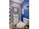 Bathroom featuring a toilet, sink with vanity, blue accent wall, and a shower with blue and white curtain at 321 S Biltmore Ave, Indianapolis, IN 46241