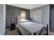 Bedroom featuring a dark gray accent wall, a bed with wood frames, and wood blinds on the window at 321 S Biltmore Ave, Indianapolis, IN 46241