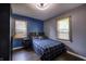 Cozy bedroom with a large window, hardwood floors, and a blue accent wall at 321 S Biltmore Ave, Indianapolis, IN 46241