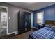 A bedroom with built in wardrobe, hardwood flooring and a blue accent wall at 321 S Biltmore Ave, Indianapolis, IN 46241