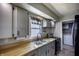 Traditional kitchen with wood countertops, stainless steel sink, gray cabinets and updated stainless steel appliances at 321 S Biltmore Ave, Indianapolis, IN 46241