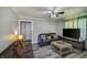 Comfortable living room featuring wood-look floors, large windows, and a ceiling fan at 321 S Biltmore Ave, Indianapolis, IN 46241