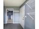 Mudroom featuring a white door, gray walls, and overhead shelving, with a glimpse into the laundry area at 321 S Biltmore Ave, Indianapolis, IN 46241