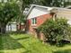 Red brick house with green grass and trees at 3520 Lantern Ln, Columbus, IN 47203