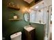 Elegantly designed bathroom features a glass enclosed shower, dark green walls and gold fixtures at 3520 Lantern Ln, Columbus, IN 47203
