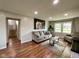 Cozy living room with a comfortable gray sofa, wood floors, and access to the stairs at 3520 Lantern Ln, Columbus, IN 47203