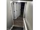 View down the staircase to a landing with open doors and neutral decor at 3949 Chateau Dr, Indianapolis, IN 46226