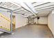 Unfinished basement featuring painted flooring and exposed ceiling, with a utility system and stairs visible at 4048 N College Ave, Indianapolis, IN 46205
