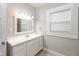 Bathroom with new vanity, framed mirror, and a window providing natural light at 4048 N College Ave, Indianapolis, IN 46205