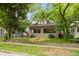 Well-maintained home featuring a covered front porch and inviting curb appeal, set among mature trees at 4048 N College Ave, Indianapolis, IN 46205