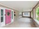 Charming covered front porch with a pink door, offering a relaxing space to enjoy the neighborhood views at 4048 N College Ave, Indianapolis, IN 46205