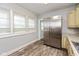 Bright kitchen with stainless steel refrigerator, hardwood floors, and natural light from the large window at 4048 N College Ave, Indianapolis, IN 46205