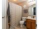 Well-lit bathroom featuring a shower with curtain, toilet, and wooden vanity with sink at 420 Beverly Ct, Carmel, IN 46032