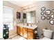 Bathroom with double sinks, neutral walls, and decorative mirrors at 420 Beverly Ct, Carmel, IN 46032