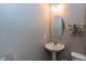 Powder room with pedestal sink, round mirror, and towel rack at 420 Beverly Ct, Carmel, IN 46032