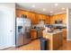 Well-lit kitchen with stainless steel appliances, wood cabinets and granite countertops at 420 Beverly Ct, Carmel, IN 46032