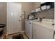 Functional laundry room equipped with a washer, dryer, and built-in storage shelves at 420 Beverly Ct, Carmel, IN 46032