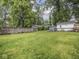 Expansive backyard with lush lawn, privacy fence, and charming outbuilding for outdoor enjoyment at 4455 Central Ave, Indianapolis, IN 46205