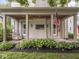 Inviting front porch with swing, featuring wood ceiling, brick accents, and view of lawn at 4455 Central Ave, Indianapolis, IN 46205