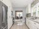 Galley kitchen featuring tile floors, modern appliances, and window looking into breakfast area at 4455 Central Ave, Indianapolis, IN 46205