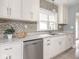 Updated kitchen with stainless steel dishwasher, white cabinetry, and mosaic backsplash at 4455 Central Ave, Indianapolis, IN 46205