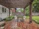An inviting brick patio under a wooden pergola with string lights creates a delightful outdoor dining space at 4455 Central Ave, Indianapolis, IN 46205