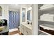 Updated bathroom featuring dual sinks, elegant mirror, and organized storage shelves at 47 Oakwood Ct, Brownsburg, IN 46112