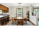 A dining room with a wooden table and chairs beneath a modern light fixture next to the kitchen at 47 Oakwood Ct, Brownsburg, IN 46112