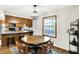 A dining room with a wooden table and chairs beneath a modern light fixture connected to the kitchen at 47 Oakwood Ct, Brownsburg, IN 46112