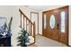 Welcoming foyer featuring a wooden staircase, decorative front door, and neutral color palette at 47 Oakwood Ct, Brownsburg, IN 46112
