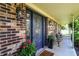 Inviting front porch with a beautifully detailed front door, brick accents, and potted flowers at 47 Oakwood Ct, Brownsburg, IN 46112
