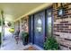 Elegant front porch featuring a decorative front door, brick accents, and comfortable seating at 47 Oakwood Ct, Brownsburg, IN 46112
