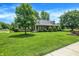 Beautiful brick home with a lush green lawn, mature trees, and meticulous landscaping at 47 Oakwood Ct, Brownsburg, IN 46112