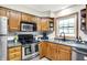 Kitchen featuring stainless steel appliances, wood cabinets, and a window above the sink at 47 Oakwood Ct, Brownsburg, IN 46112