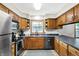 Kitchen with wooden cabinets and stainless steel appliances and sink beneath a window at 47 Oakwood Ct, Brownsburg, IN 46112