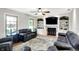 Bright living room featuring custom built-in shelving, a fireplace, and comfortable seating at 47 Oakwood Ct, Brownsburg, IN 46112