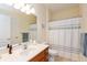 Well-lit bathroom featuring a large mirror, vanity with sink, and shower with a patterned curtain at 5229 Imperial Dr, Columbus, IN 47203