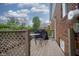 Back deck with a glass table and two chairs and a grill covered next to the brick wall of the home at 5435 E 10Th St, Indianapolis, IN 46219