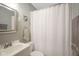 Bathroom with white fixtures and shower with white curtain at 5435 E 10Th St, Indianapolis, IN 46219