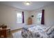Bedroom with two windows, floral bedding, area rug, and hardwood floors at 5435 E 10Th St, Indianapolis, IN 46219