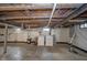 Unfinished basement featuring concrete floor, exposed wood ceiling, and utility connections, ready for customization at 5516 W Minnesota St, Indianapolis, IN 46241