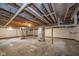 Unfinished basement featuring concrete floor, exposed wood ceiling, and utility connections, ready for customization at 5516 W Minnesota St, Indianapolis, IN 46241