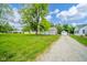 Landscaped front yard and long gravel driveway that leads to a detached garage at 5516 W Minnesota St, Indianapolis, IN 46241